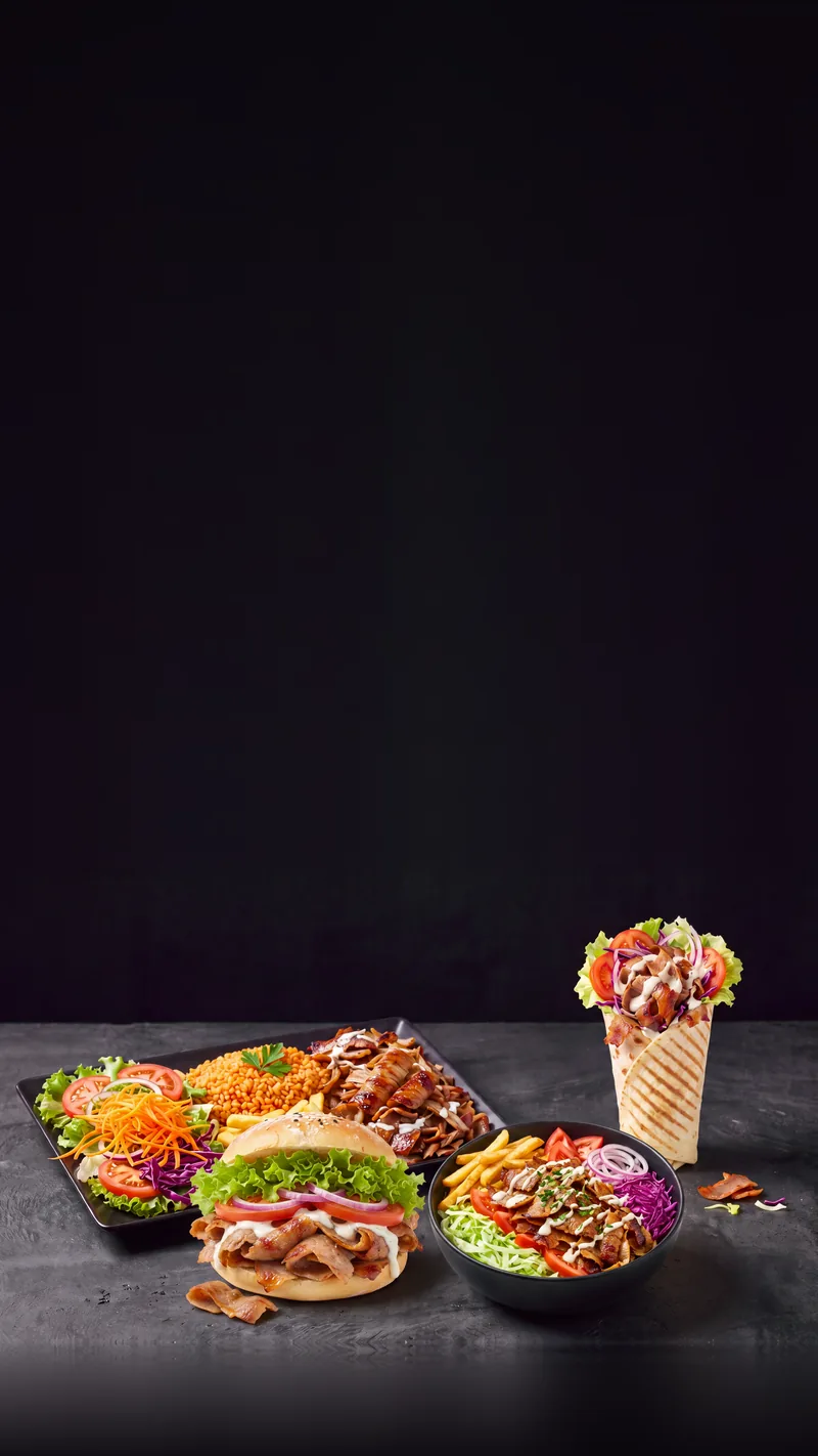 Un kebab dans son pain rond au sésame : viande grillée, salade, tomate, chou rouge et sauce blanche